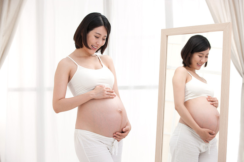 孕妇站在镜子前面图片下载