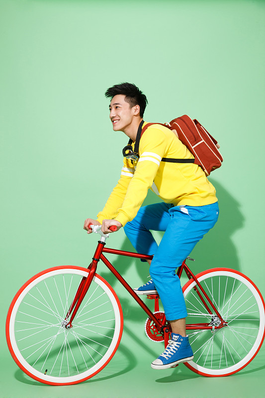 时尚的青年男人骑自行车图片下载