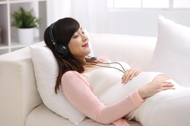 孕妇躺在沙发上听音乐图片下载