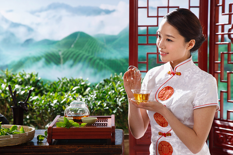 一个东方青年女人在茶园喝茶图片素材