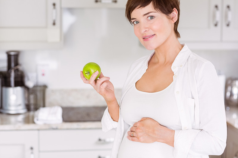 孕妇在家厨房吃苹果图片下载