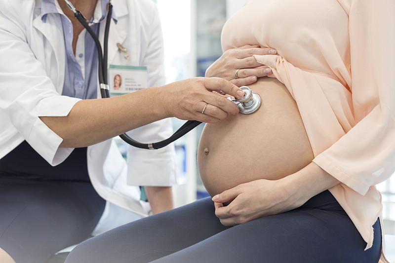 医生对孕妇使用听诊器?年代的胃图片素材