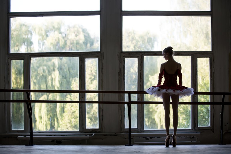 优雅的年轻芭蕾舞演员站在一扇大窗户旁跳舞图片下载