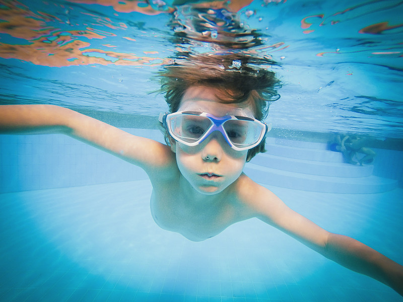 在游泳池里游泳的男孩的肖像图片下载