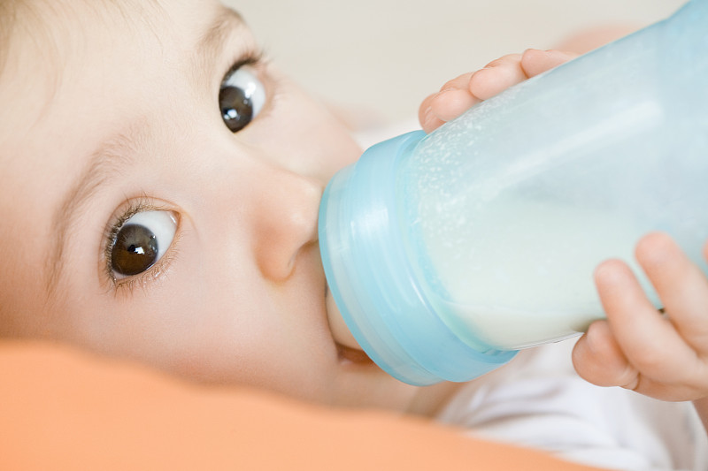 小男孩喝着奶瓶里的牛奶图片下载