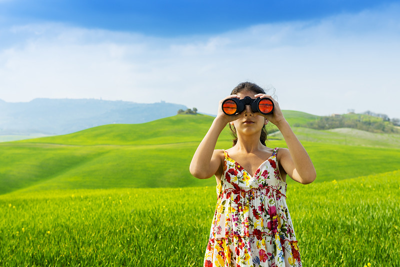 小女孩在意大利托斯卡纳用双筒望远镜探险图片素材