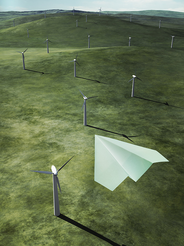 纸飞机在风力发电场上空飞行图片素材