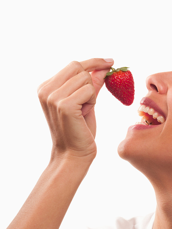 微笑的女人在吃草莓图片素材