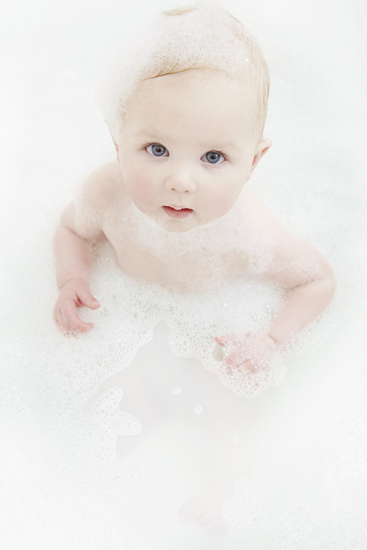 女婴坐在泡泡浴中图片下载