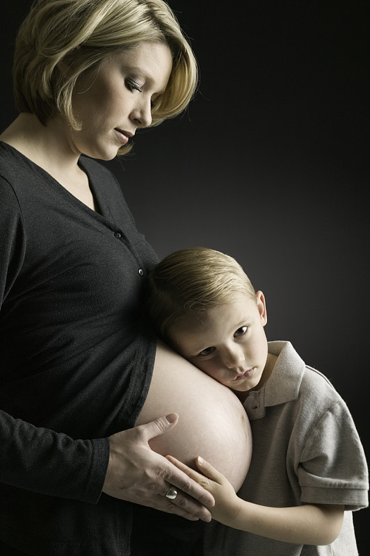 男孩(6-7岁)耳朵紧贴着孕妇的肚子图片下载
