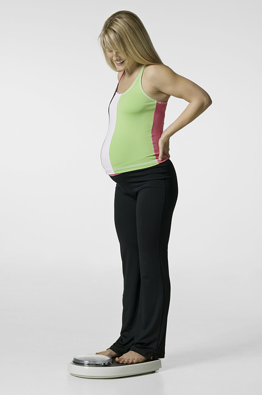 一名孕妇在演播室称量体重图片下载