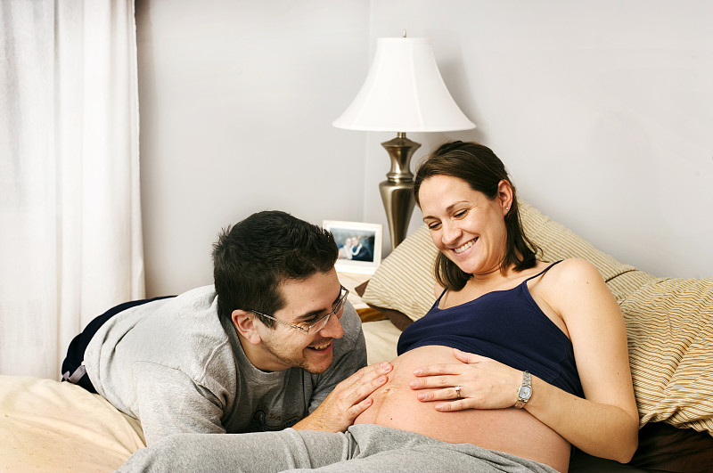 丈夫抚摸怀孕妻子的腹部图片下载