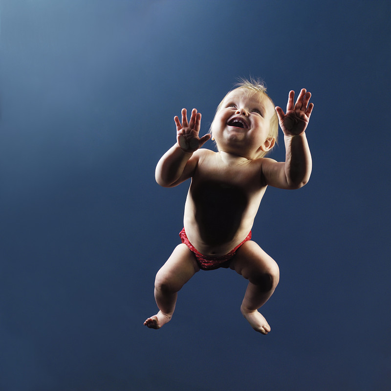 女婴(9-12个月)在玻璃上爬行，从下面观看图片下载