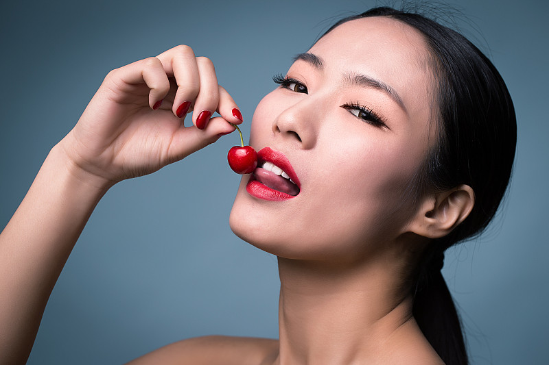 亚洲女性喜欢化妆和樱桃图片素材