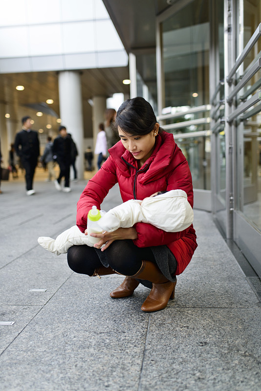 年轻的母亲在户外给婴儿喂奶图片下载