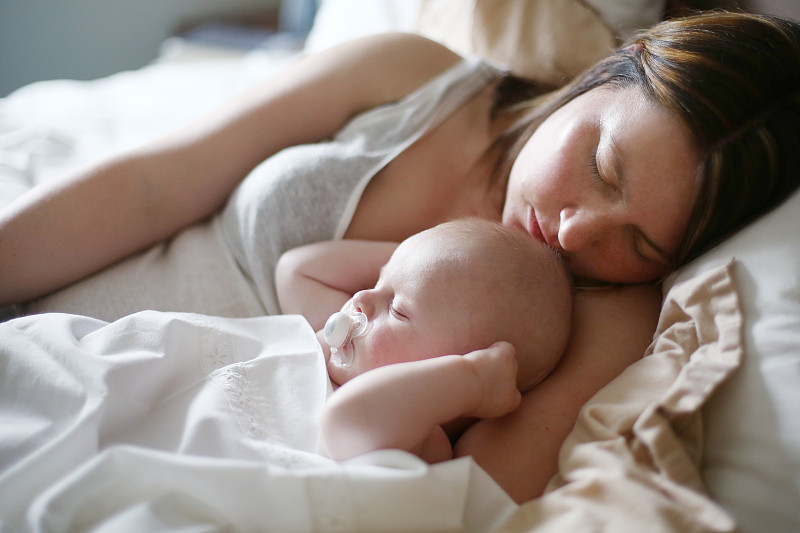 一位母亲和她3个月大的婴儿一起睡觉图片下载