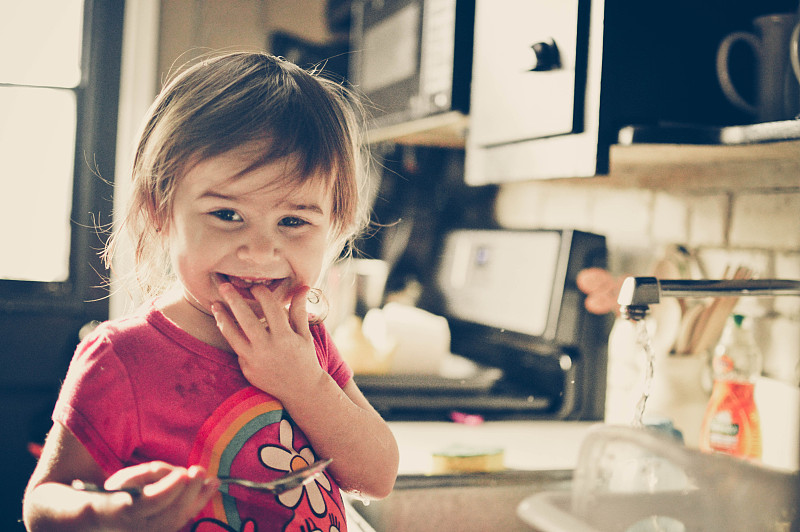 小女孩在厨房微笑。图片素材