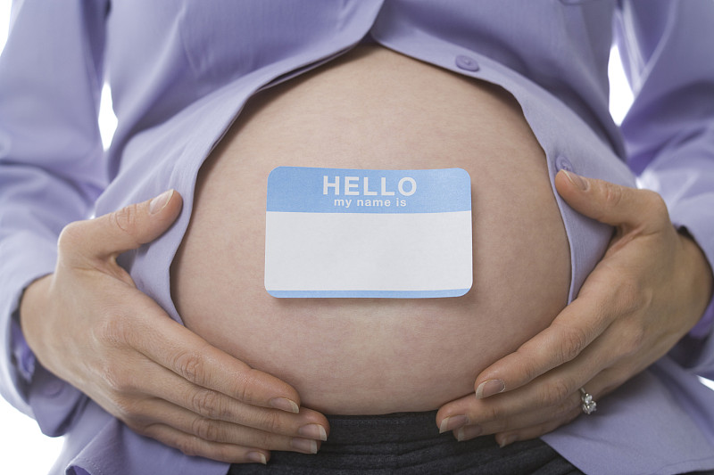 一个孕妇腹部有一个名字标签的中段视图图片素材