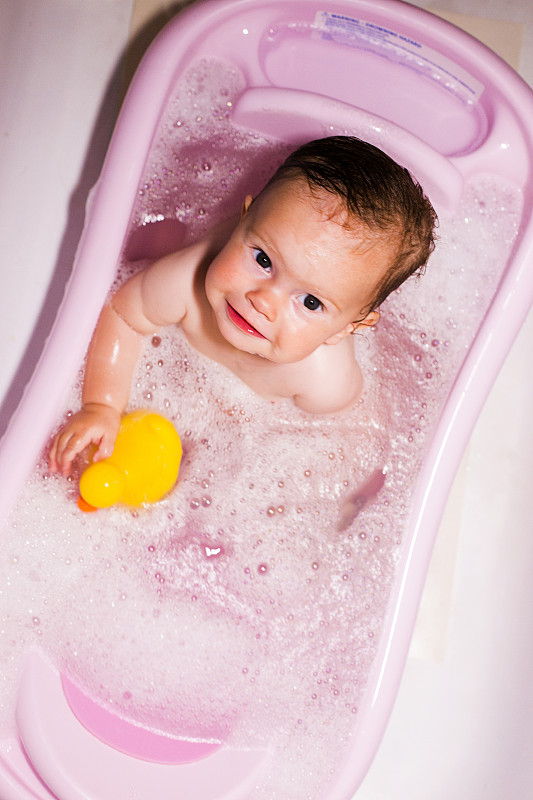 一个白人女婴坐在浴缸里图片素材