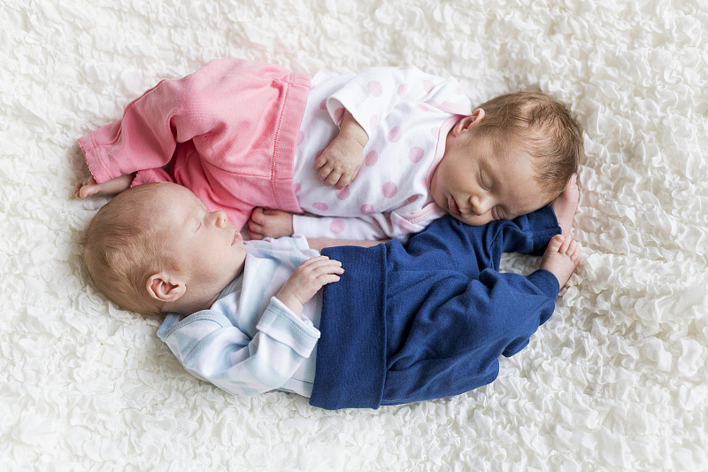 刚出生的双胞胎睡在白色的毯子上图片下载