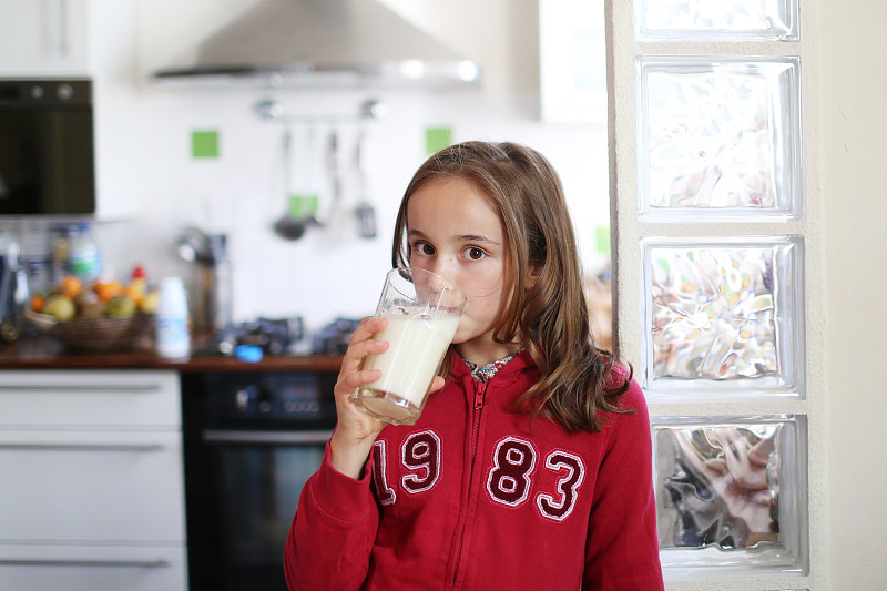 一个10岁的女孩在喝一杯牛奶图片下载