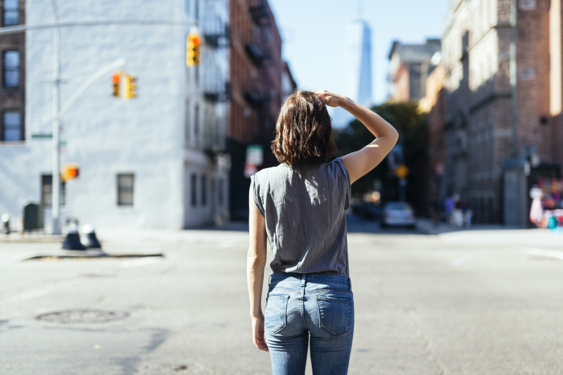 USA, New York City, back view of young woman standing on a street图片素材