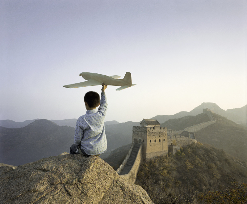 男孩在长城上玩飞机模型图片下载