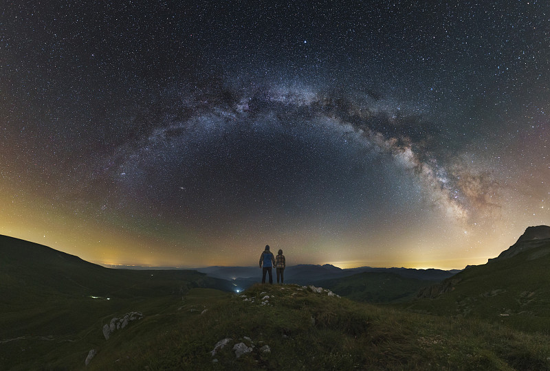 一对夫妇从拉各斯-纳基高原上俯瞰俄罗斯，凝视着银河。图片下载