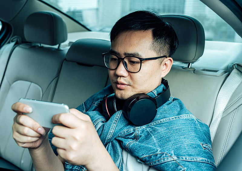 一位年轻男子在车里玩手机游戏图片下载