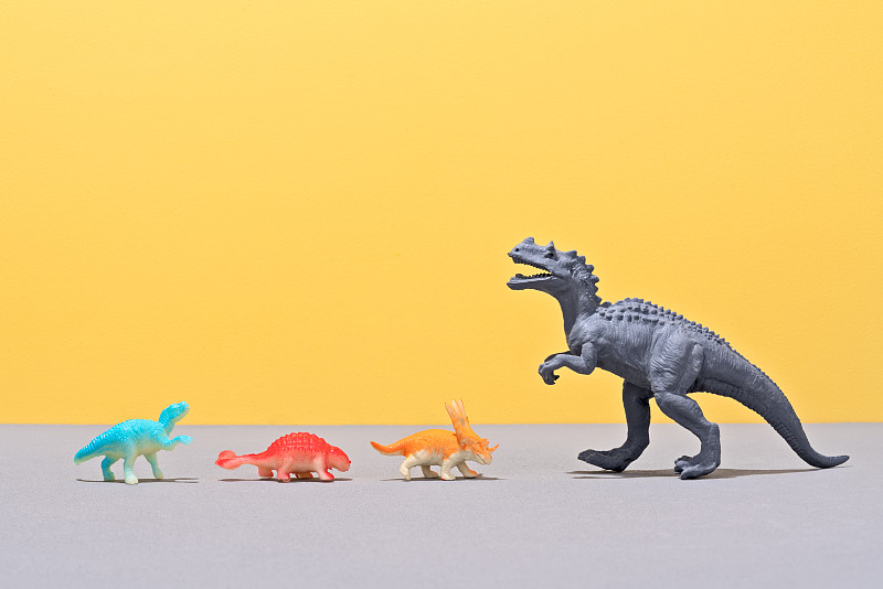 小玩具恐龙面对一个大玩具恐龙图片下载