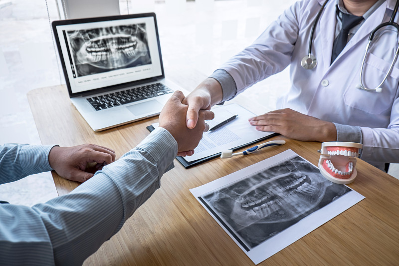 医生与病人腹部在桌子上握手图片素材