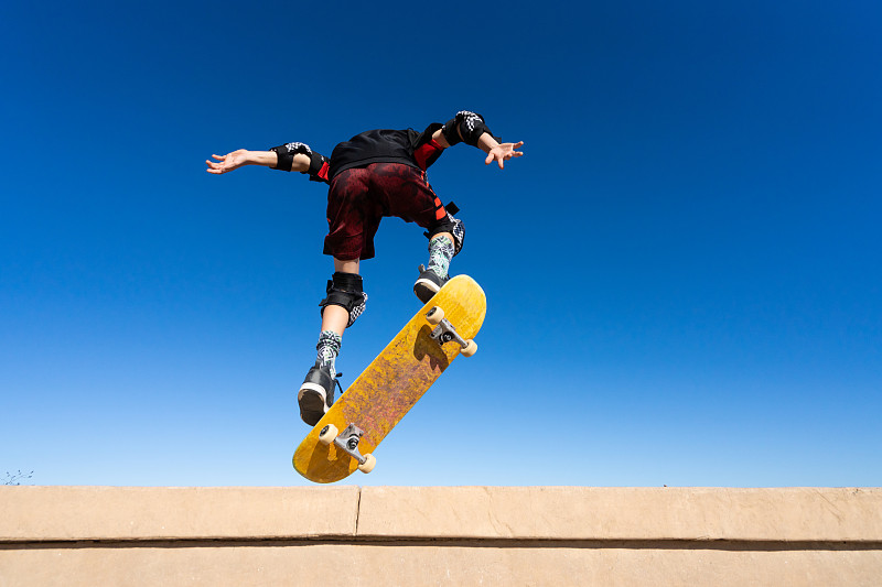 滑板上的小男孩跳向空中图片素材