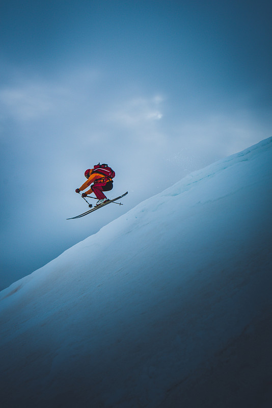 滑雪者从滑雪跳台上跳下，身后是天空图片下载