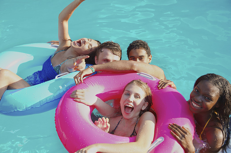 肖像顽皮的青少年朋友享受游泳池派对图片下载