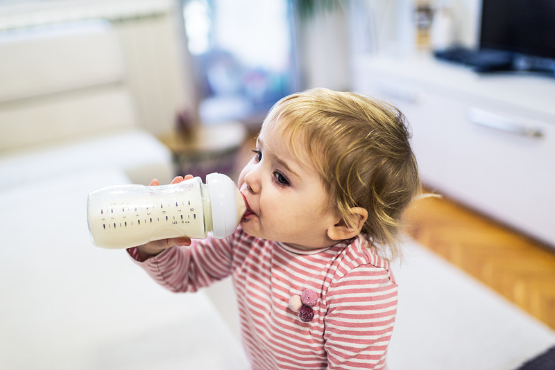 小女孩在喝瓶子里的牛奶图片素材