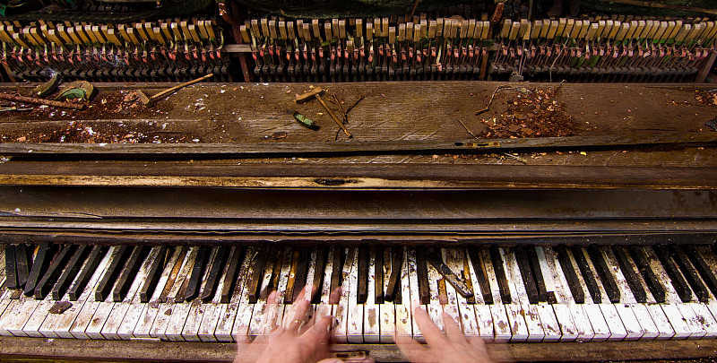 幽灵般的手弹奏着一架久经风霜的破旧钢琴图片下载