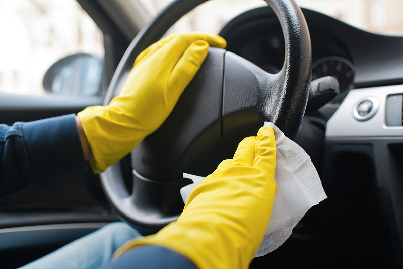 男人的手戴着橡胶手套消毒和清洁汽车内部图片素材
