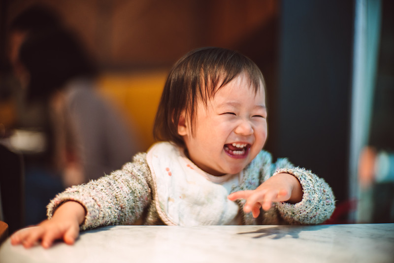 可爱的婴儿在餐厅快乐的微笑图片素材