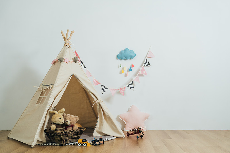 舒适气氛的儿童游戏室，游戏帐篷和填充玩具，白色的墙壁背景。空房间内部的孩子装饰可爱的配件。图片下载