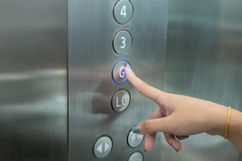 女人按电梯按钮的特写图片素材