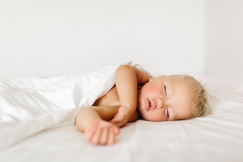 安静的婴儿躺在床上，在明亮的房间里睡觉图片素材