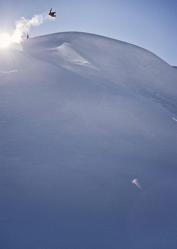 远处滑雪板在半空中跃过山坡、高山图片下载