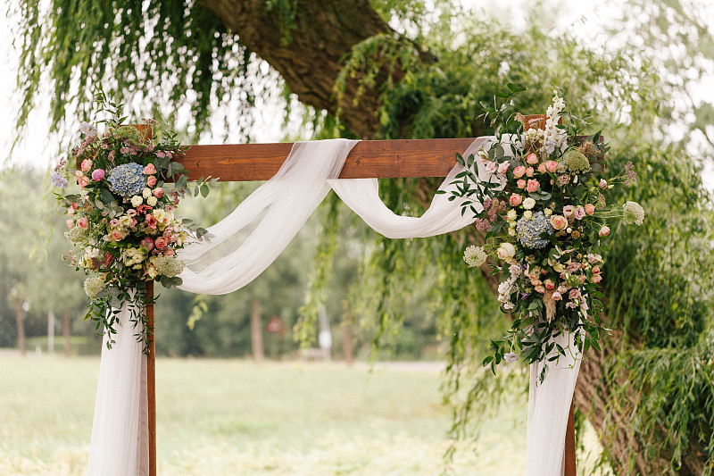 乡村的婚礼拱门，装饰着鲜花和绿色植物图片素材