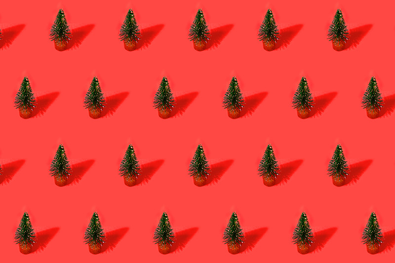 红色背景上的绿色圣诞树做成的节日图案。图片下载