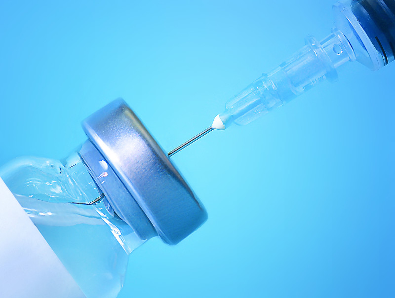 疫苗装在蓝色背景的注射器里医学,保健和科学的概念冠状病毒疫苗
