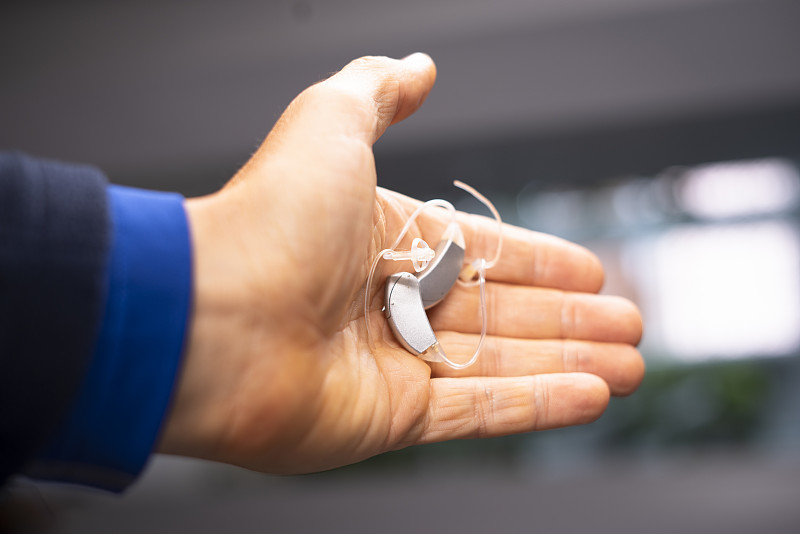 现代数字助听器在四五十岁中年人的耳朵图片下载