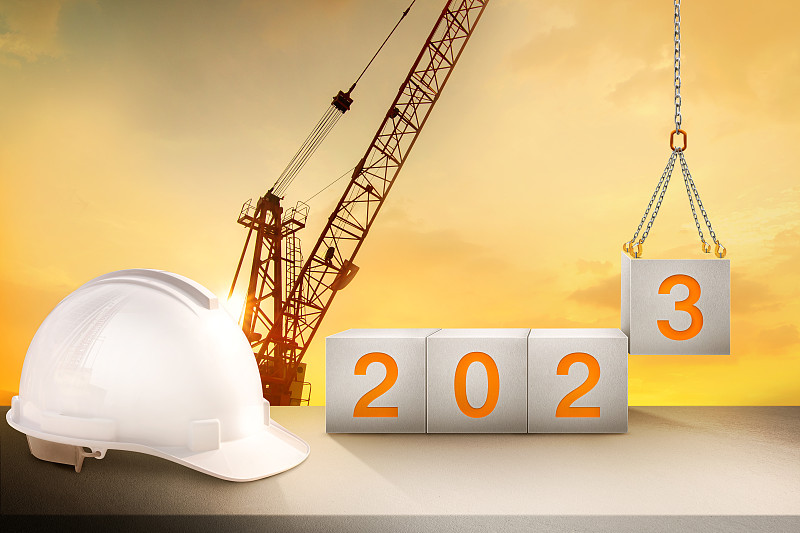 工程工作台和建筑起重机剪影和金色天空，准备迎接2023年新年晚会和改变新的业务。图片下载