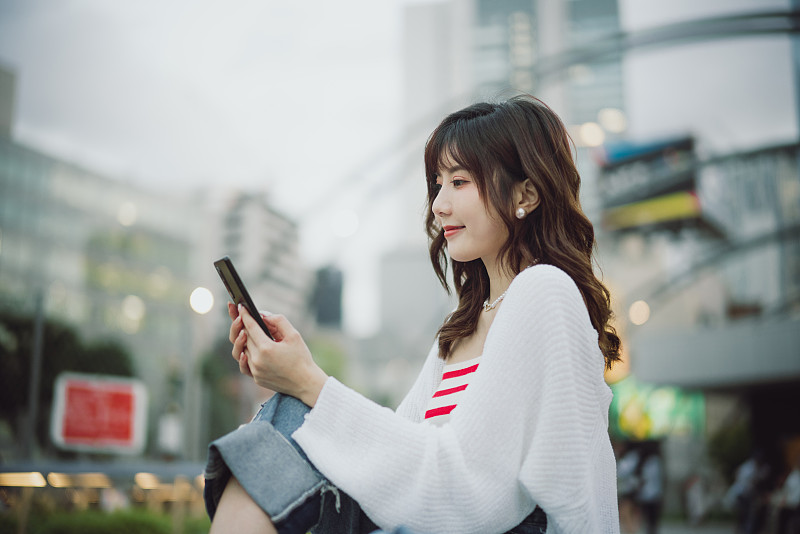 亚洲美女在东京的屋顶上使用智能手机图片下载