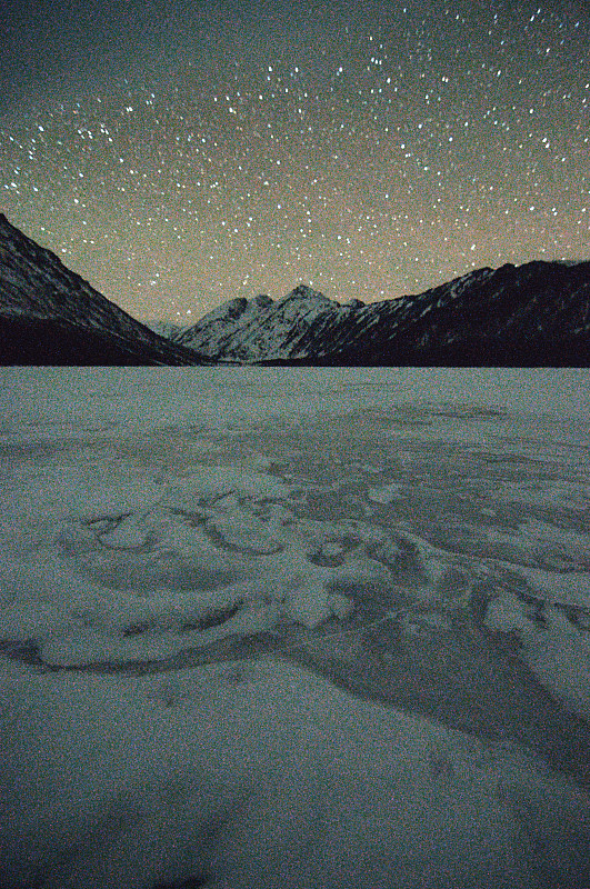 冰封的湖在夜晚的山与清澈的星空。图片下载