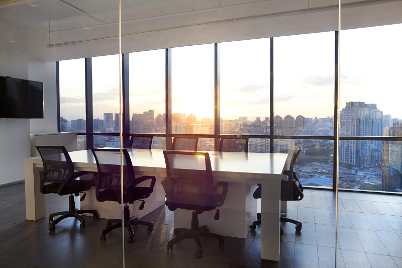 玻璃幕墙的会议室，城市景观和日落图片素材